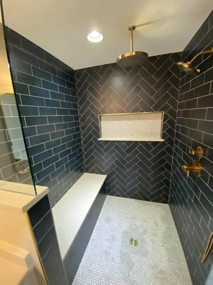 Dark tiled shower with a built-in niche